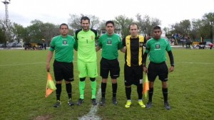 Iván Castro y Matías Píttaro. Los capitanes, junto a la terna arbitral (foto de Abraham Michref).