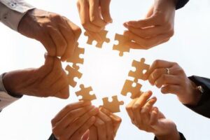 the-hand-of-a-businessman-holding-a-paper-jigsaw-and-solving-the-puzzle-together-the-business-team-assembles-a-jigsaw-puzzle-a-business-group-wishing-to-bring-together-the-puzzle-pieces-photo